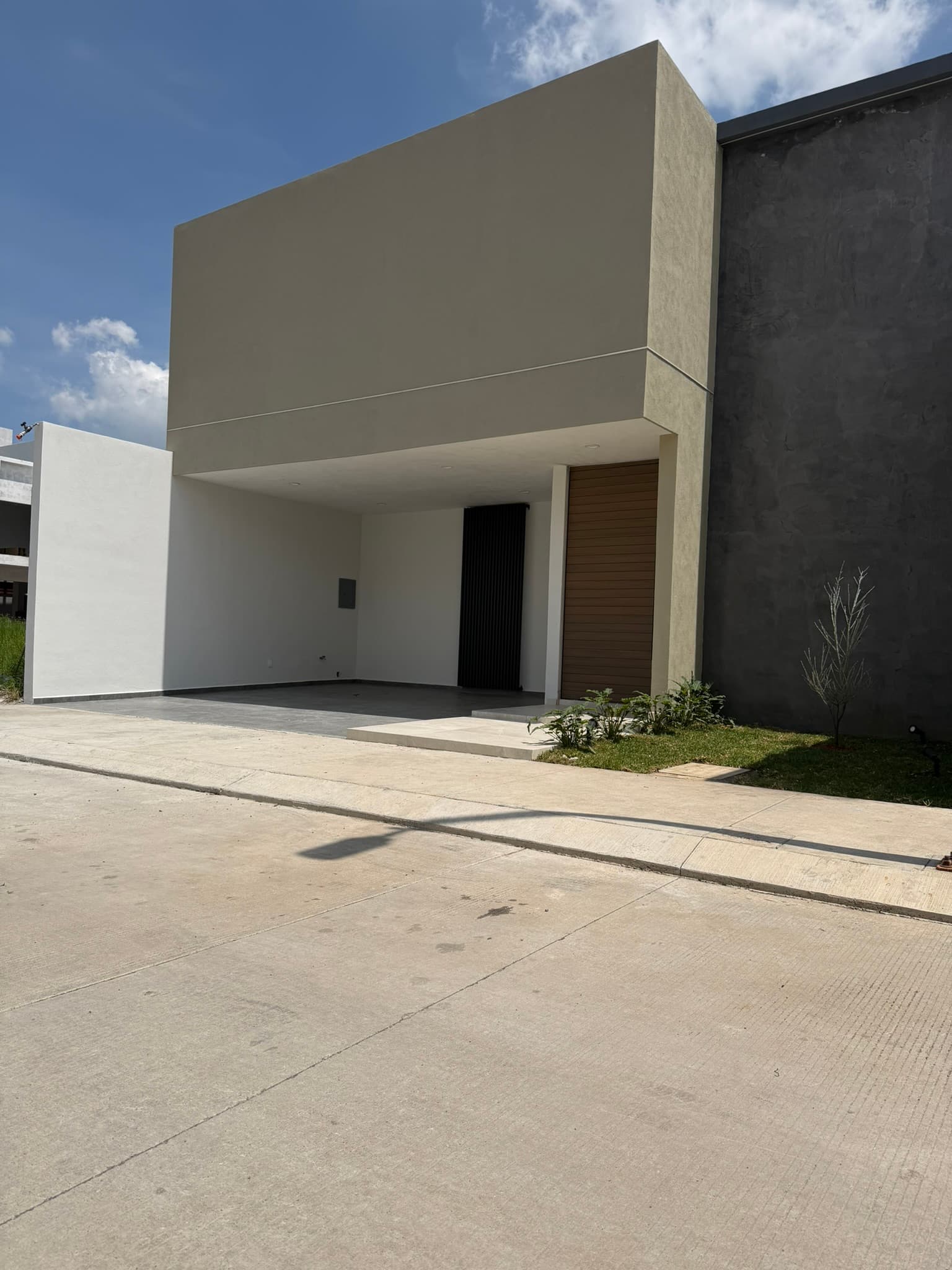 Fachada con cochera y volúmenes en tonos claros · Casa Las Américas