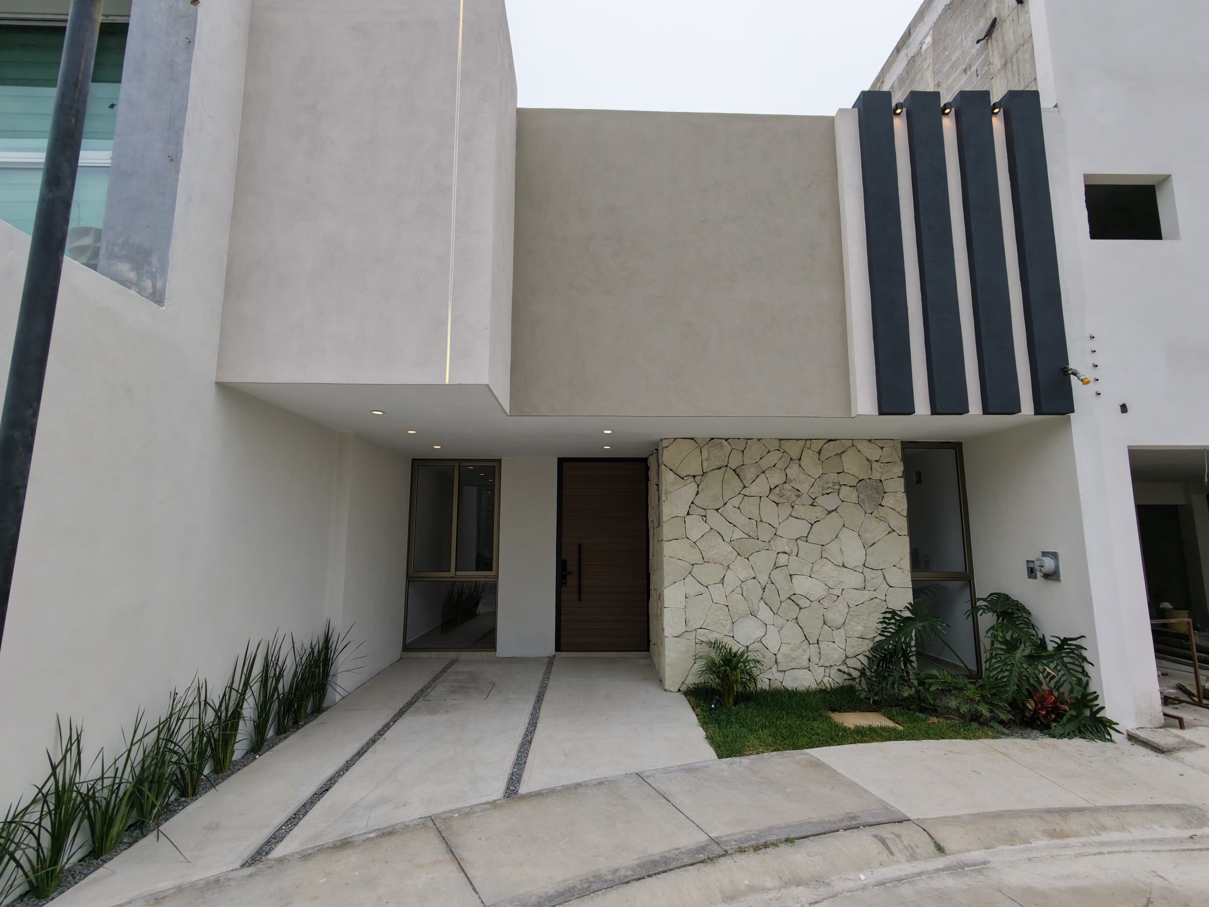 Fachada con revestimiento de piedra y acentos oscuros · Las Torres