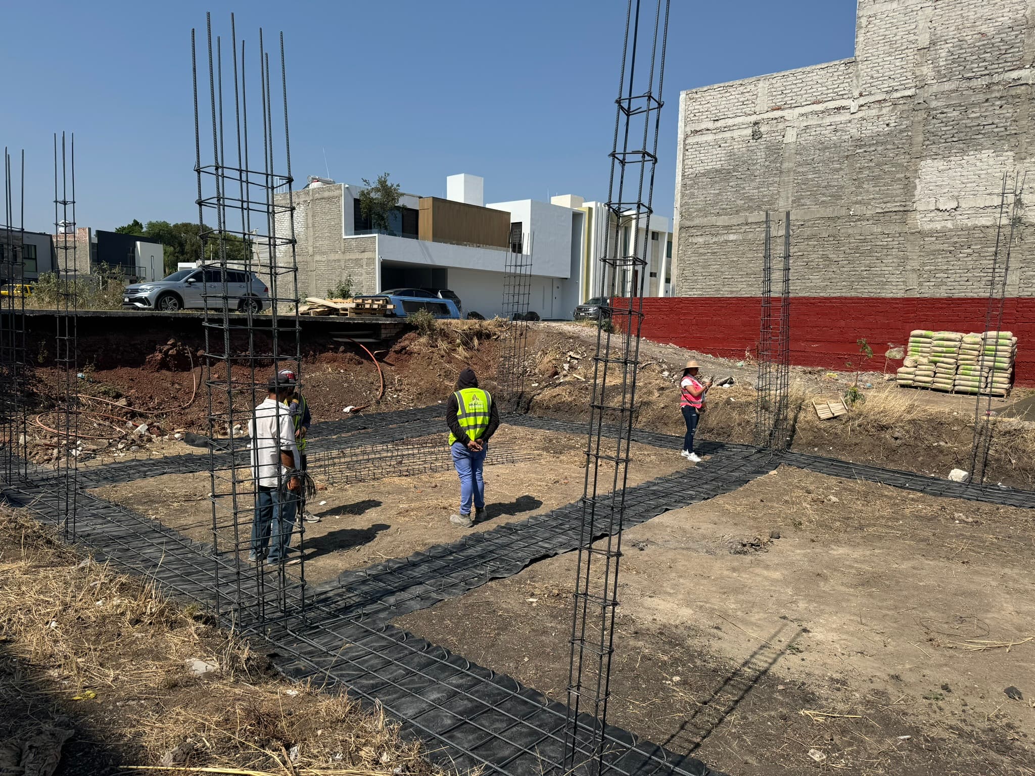Personas en una obra de Puerta del Sol junto al armado de acero y las columnas en proceso
