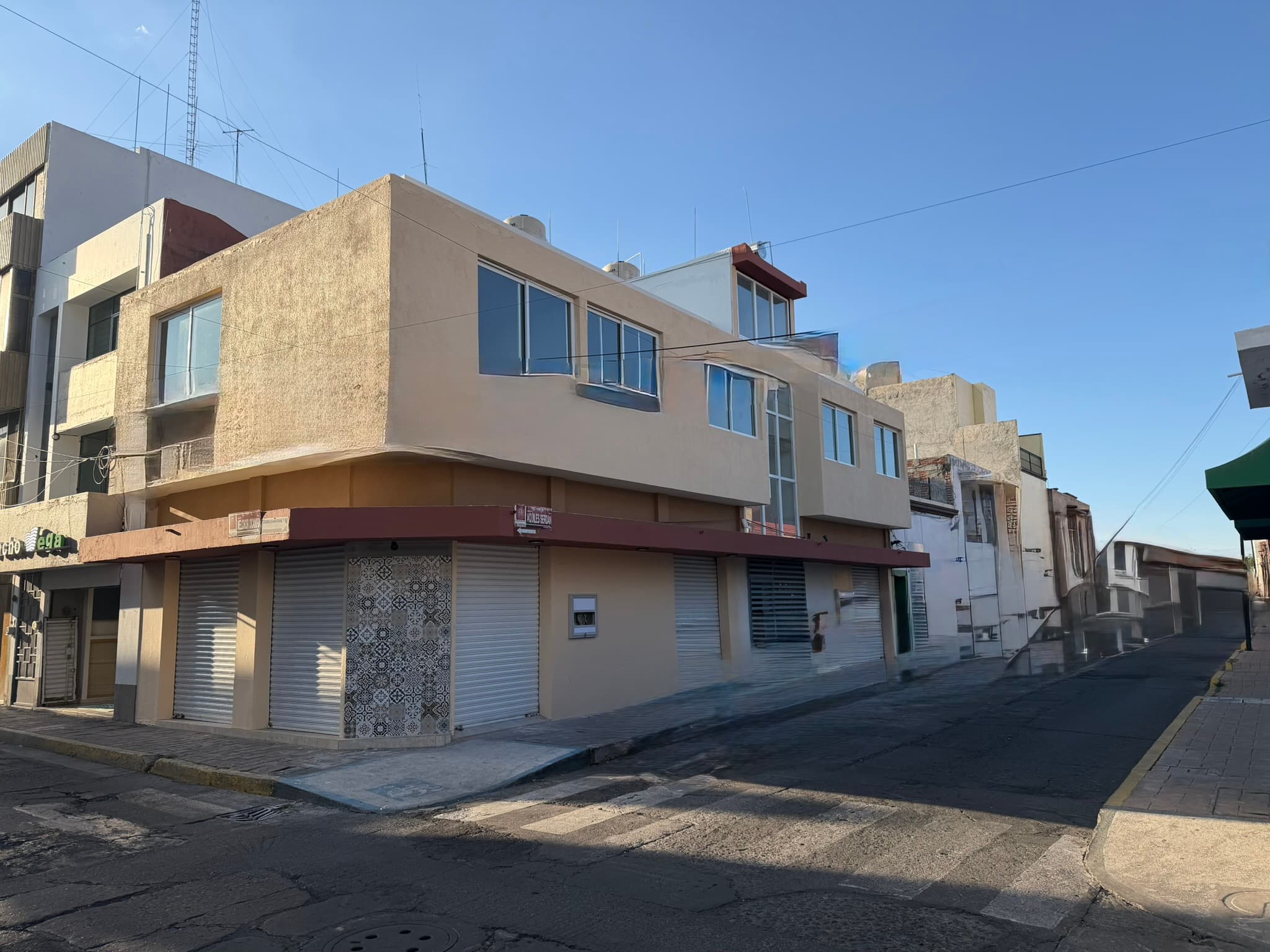 Fachada renovada del inmueble en esquina durante el día · Remodelación Aquiles Serdán