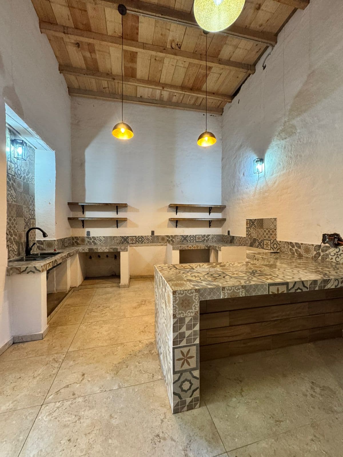 Cocina en Tlazazalca con barra de azulejos, muros claros y techo de madera
