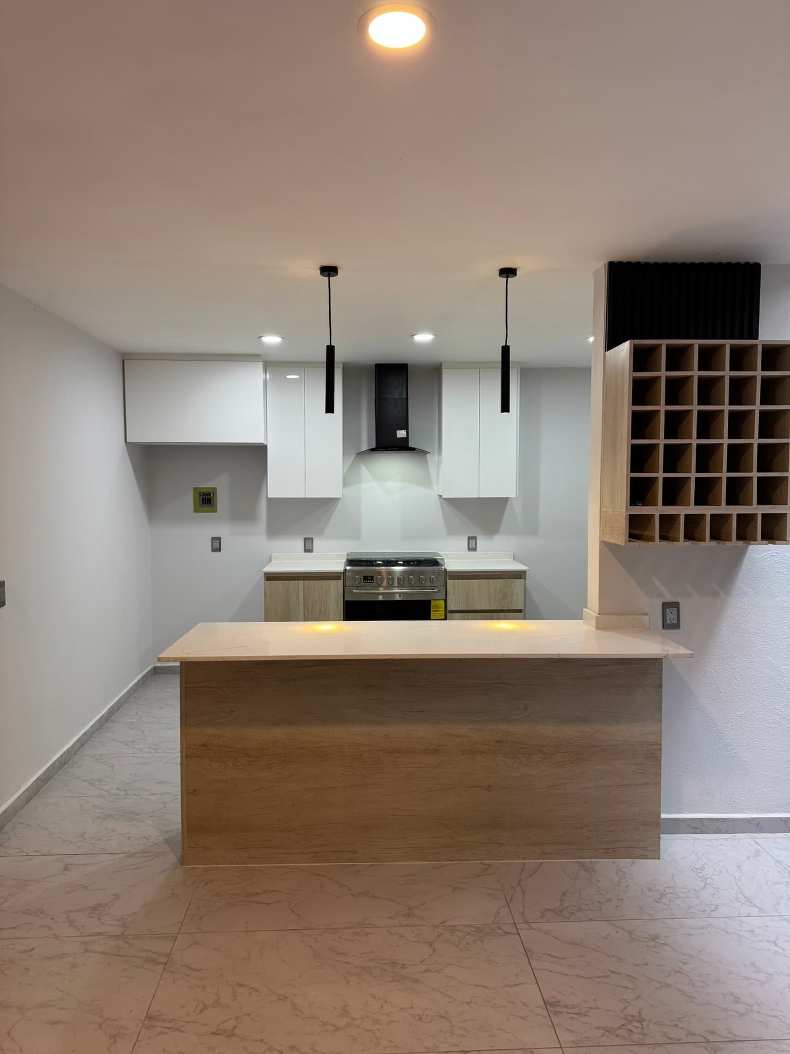 Cocina de San Nicolás con barra de madera, cubierta clara e iluminación colgante